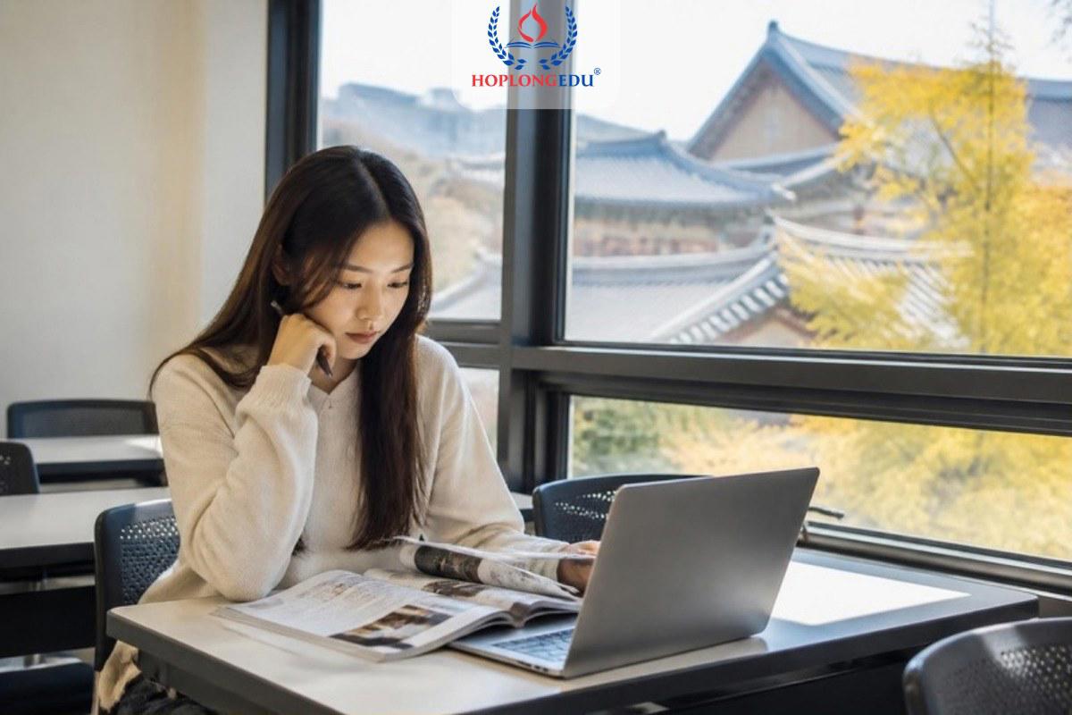Du học sinh Việt Nam ngồi trong lớp học tiếng ở Hàn Quốc, xem tài liệu để chọn ngành học lên D-2