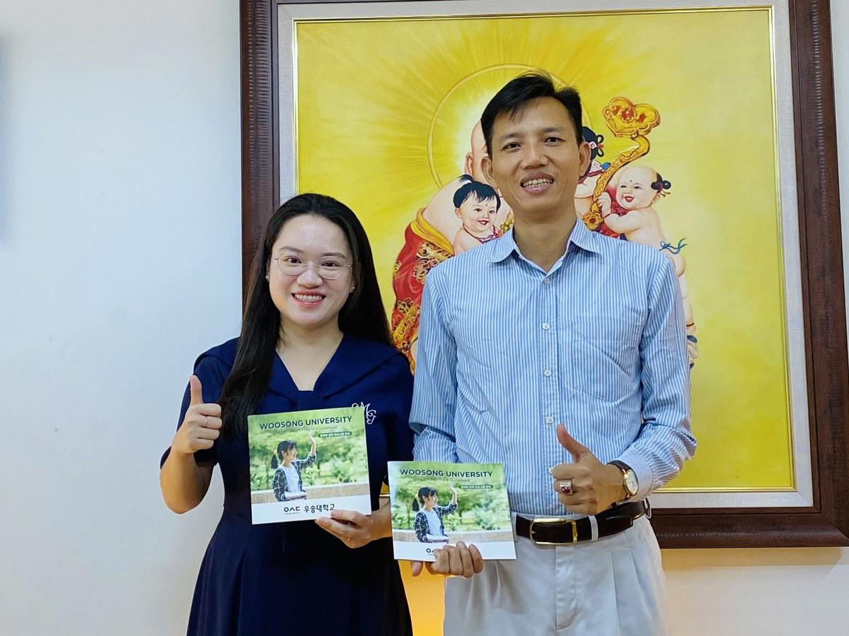 Anh Nguyễn Anh Quân của Hợp Long Education và đại diện tuyển sinh Đại học Woosong cầm sách hướng dẫn của trường tại văn phòng Hợp Long