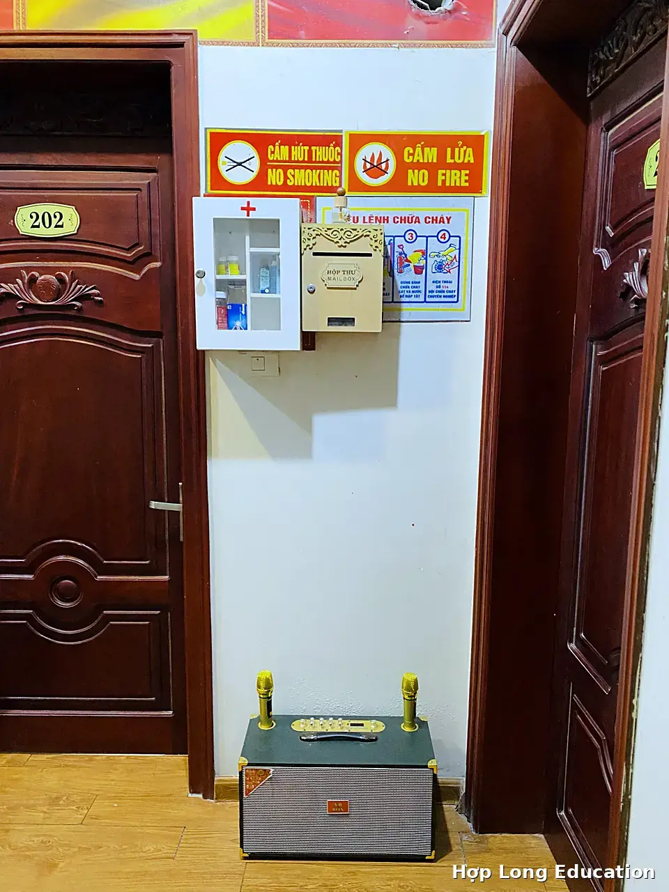 Hành lang ký túc xá Hợp Long có tủ thuốc y tế, hộp thư và bảng hướng dẫn chữa cháy