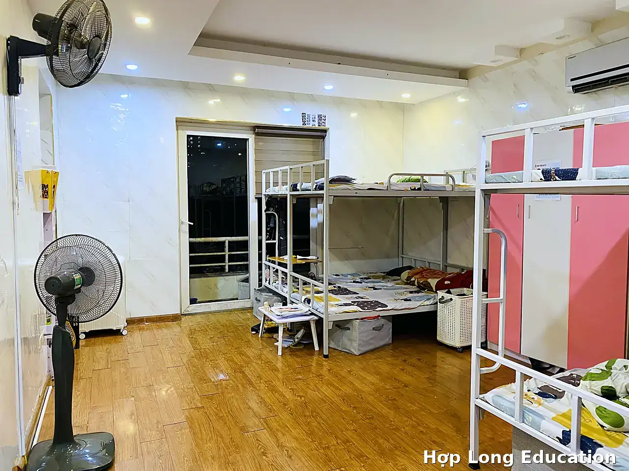 Phòng ở ký túc xá Hợp Long với giường tầng, tủ đồ, điều hòa và quạt