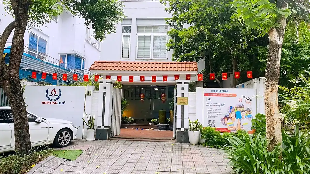 Mặt tiền trụ sở Hợp Long Education, số nhà 21, cổng mở vào sảnh có cây xanh