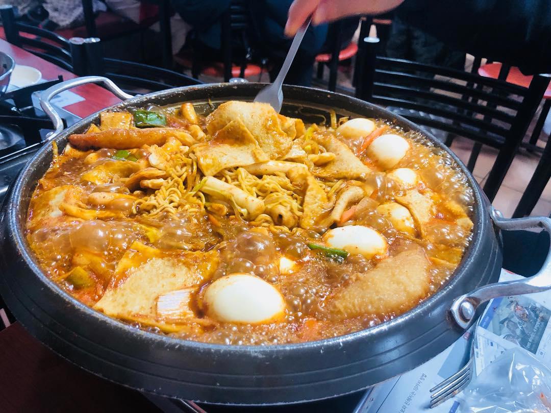 Nồi tteokbokki nấu tại bàn với bánh gạo, trứng luộc, mì và chả cá