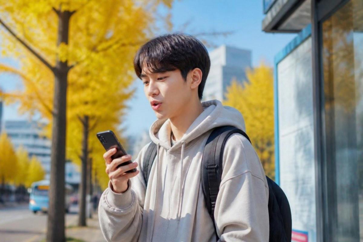 Du học sinh ôn từ vựng tiếng Hàn trên điện thoại khi chờ xe buýt ở Seoul