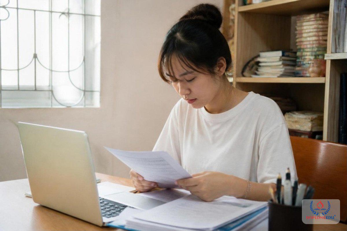Bạn nữ đọc lại giấy tờ và kế hoạch học tập trước khi nộp hồ sơ visa