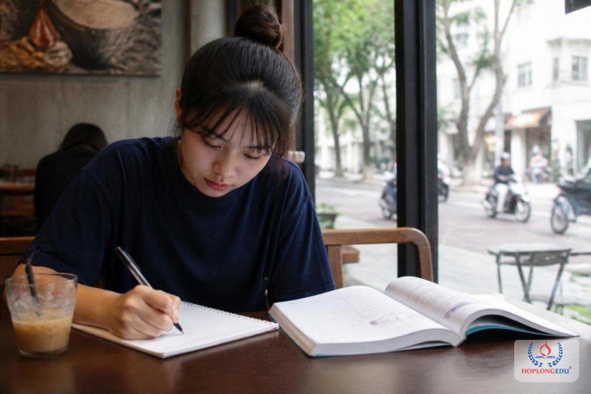Bạn nữ tự viết kế hoạch học tập bằng tay bên quyển giáo trình tiếng Hàn